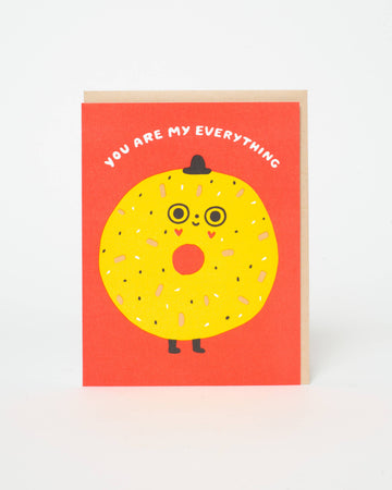 Greeting card with a yellow bagel character and text on a red background