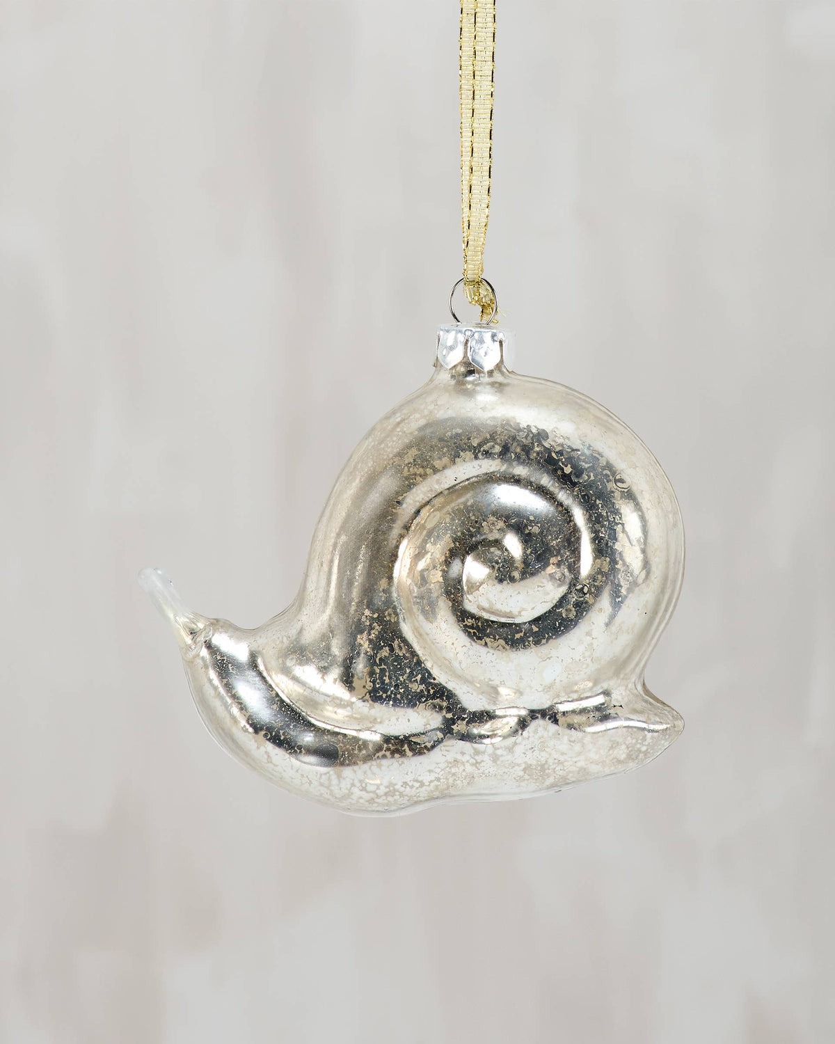 Decorative glass snail ornament on a plain background
