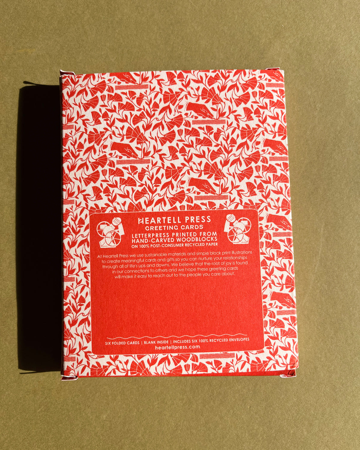 Red and white patterned greeting card box with Heartell Press branding on a green background
