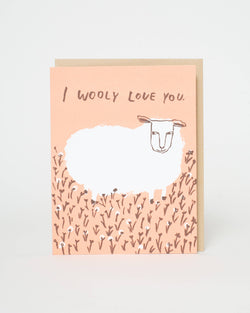 Greeting card with a sheep illustration and 'I woolly love you' text on a pink background