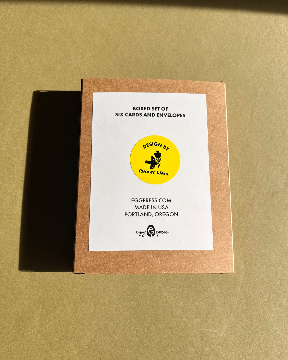 Boxed set of six cards and envelopes with a label on a beige background