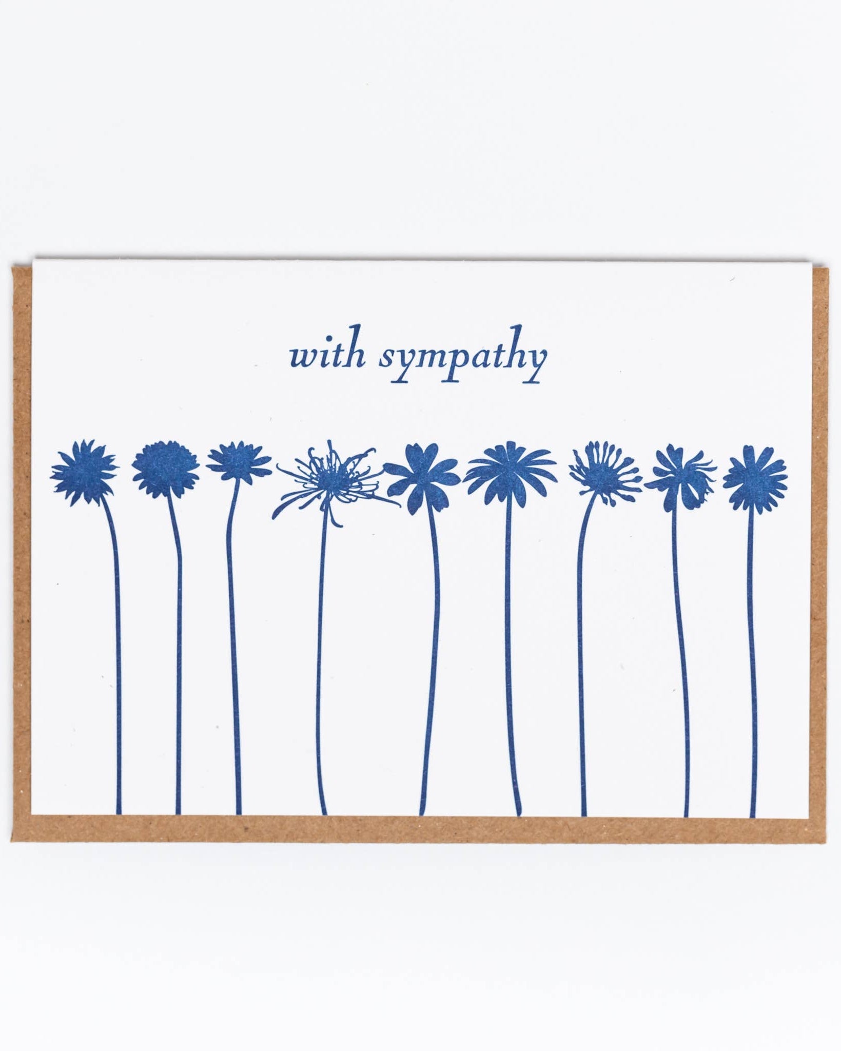 A greeting card with a letterpress printed blue floral design and the text 'with sympathy' at the top. The card is placed inside a brown biodegradable sleeve.