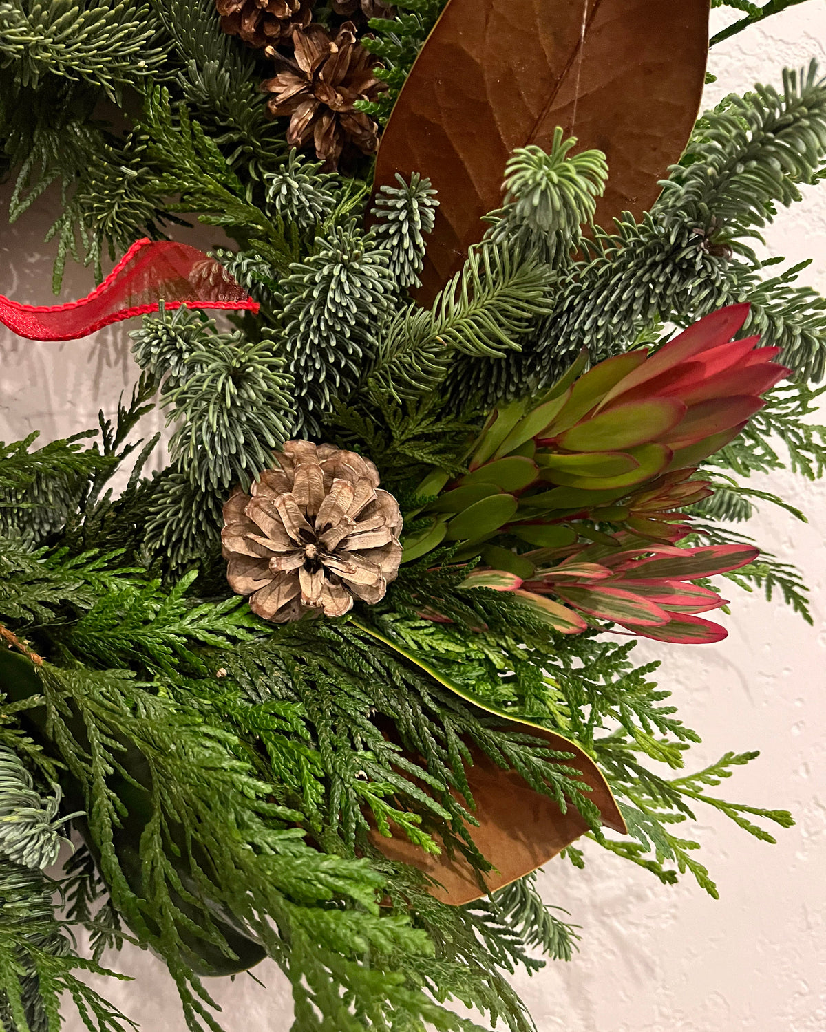 Close up of a green wreath with a pinecone
