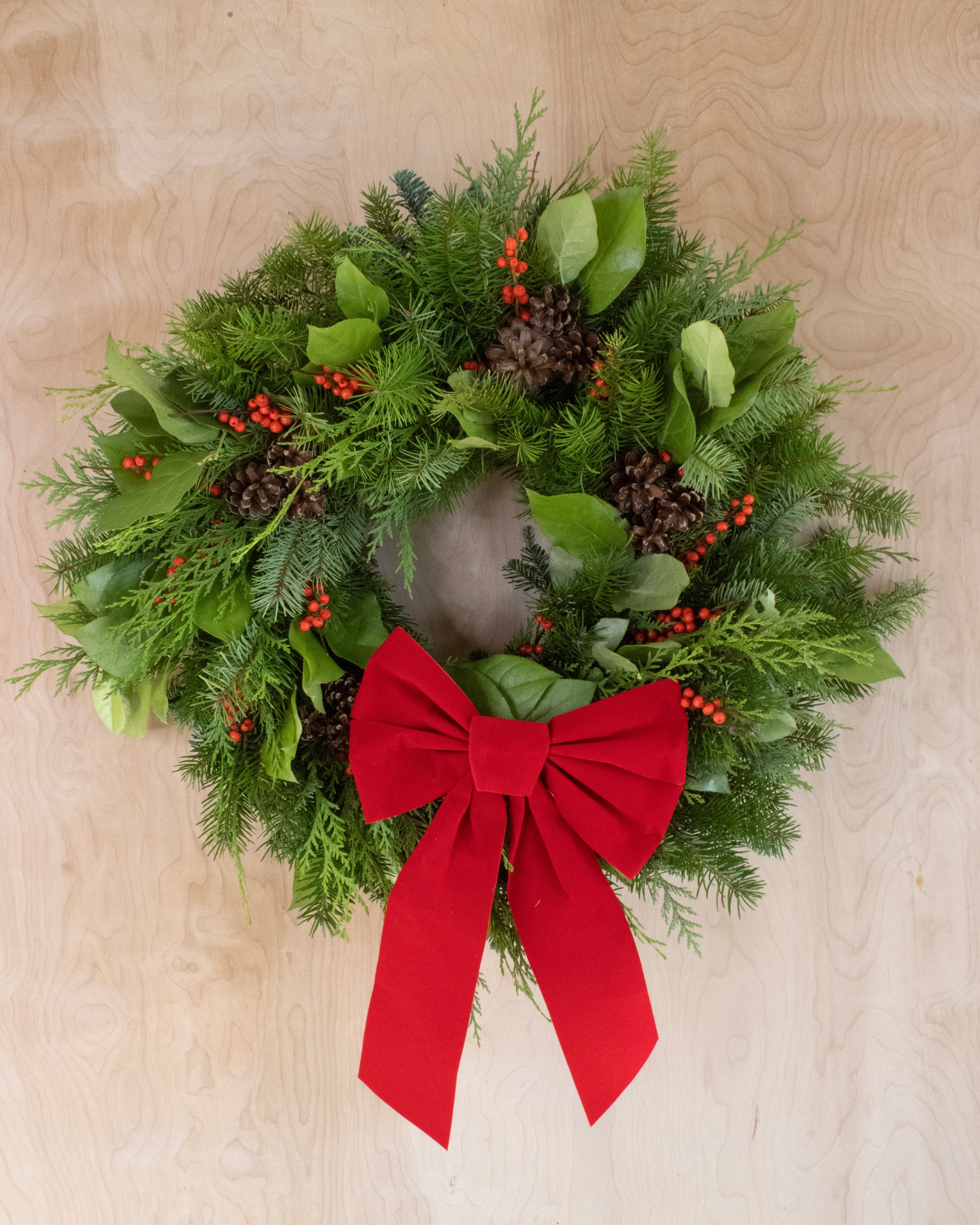 Wreath on a wood background with a large red bow
