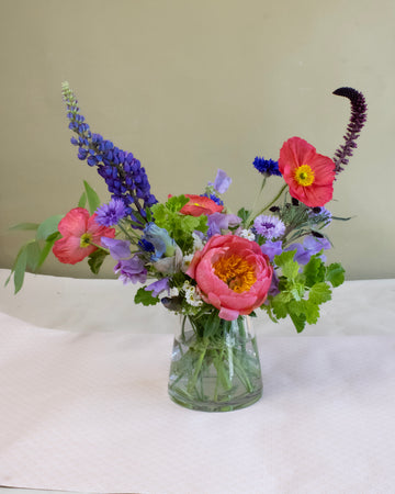 Floral arrangement in clear glass triangular vase