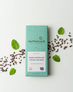 moonstruck dark chocolate cocoa nib mint bar with mint leaves on a white background