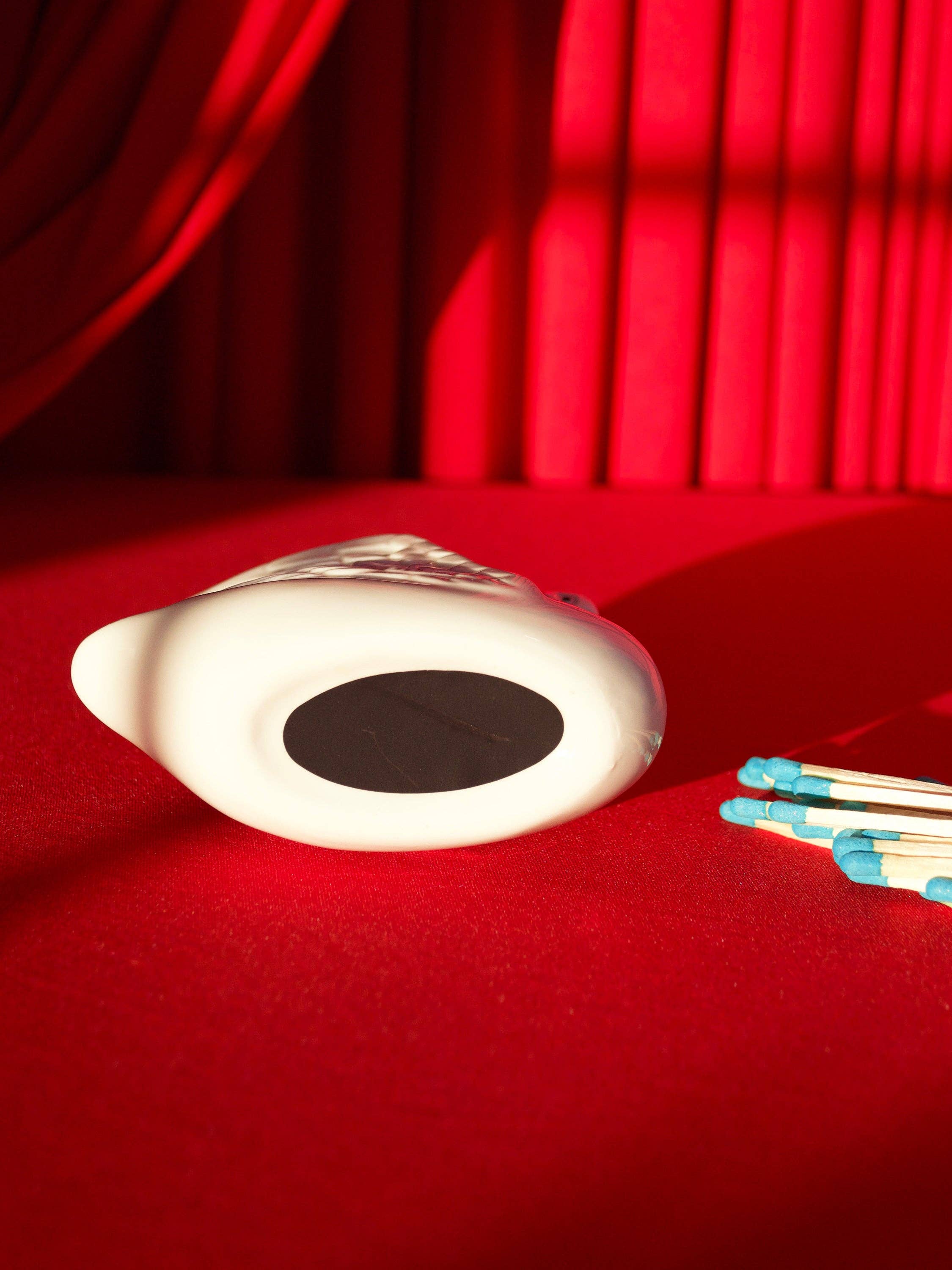 White swan match holder on a red background