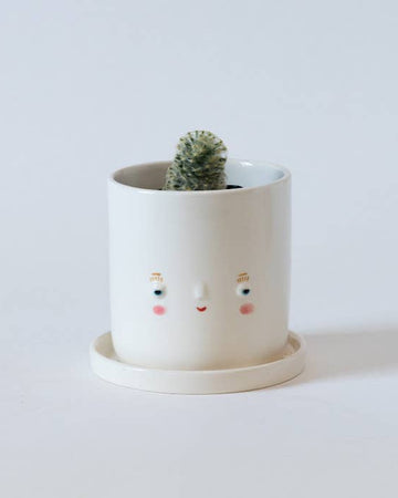smiling porcelain planter with cactus inside