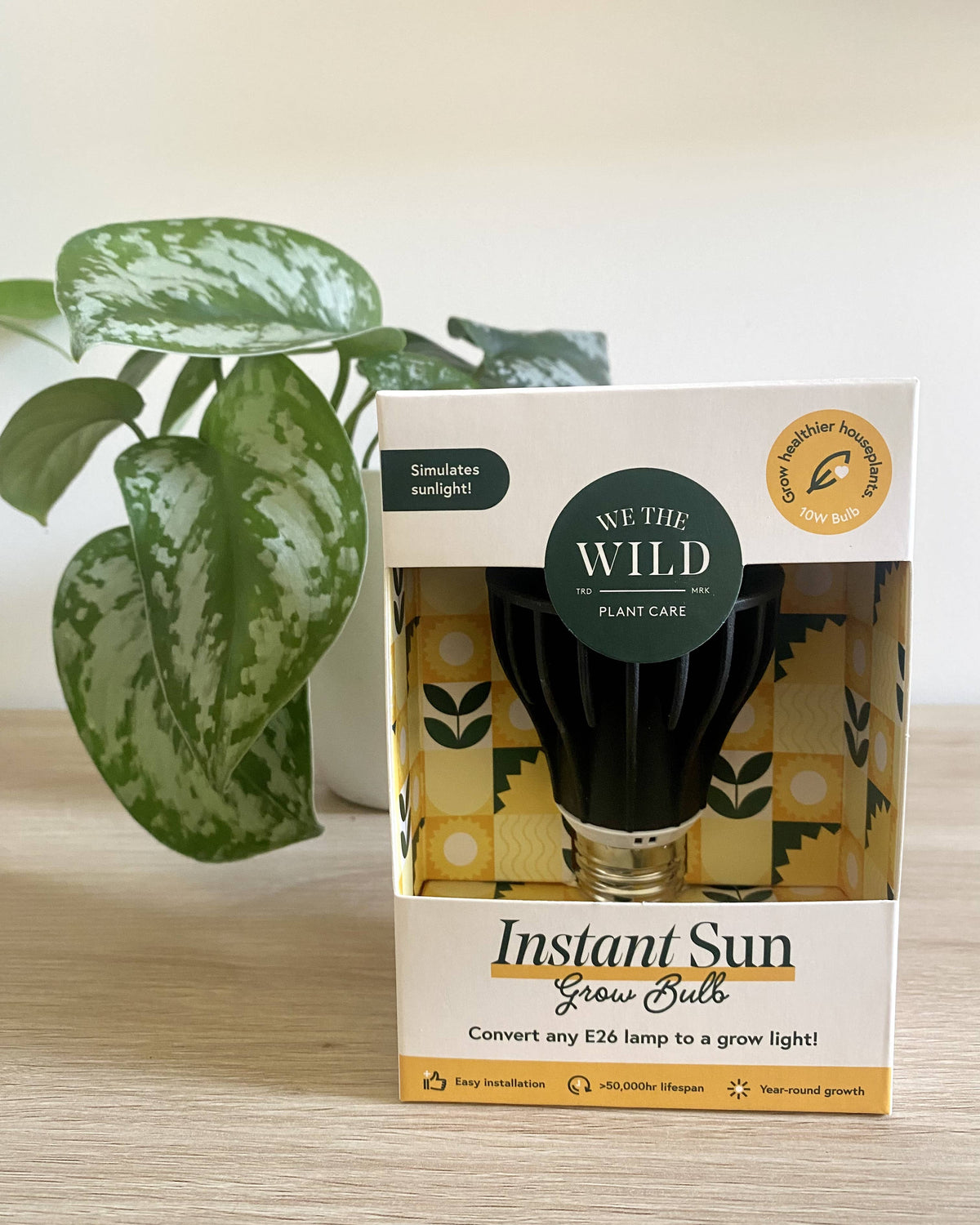 instant sun grow bulb in product packaging on table with plant in background