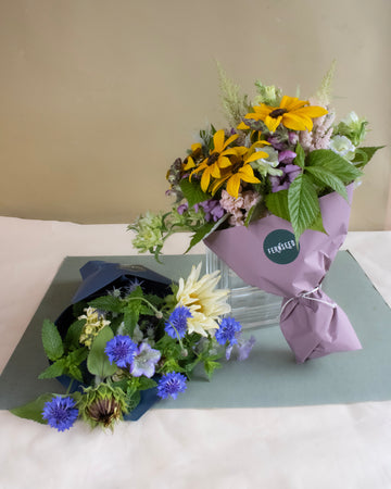 Two flower bouquets featuring sunflowers on a light surface with a neutral background