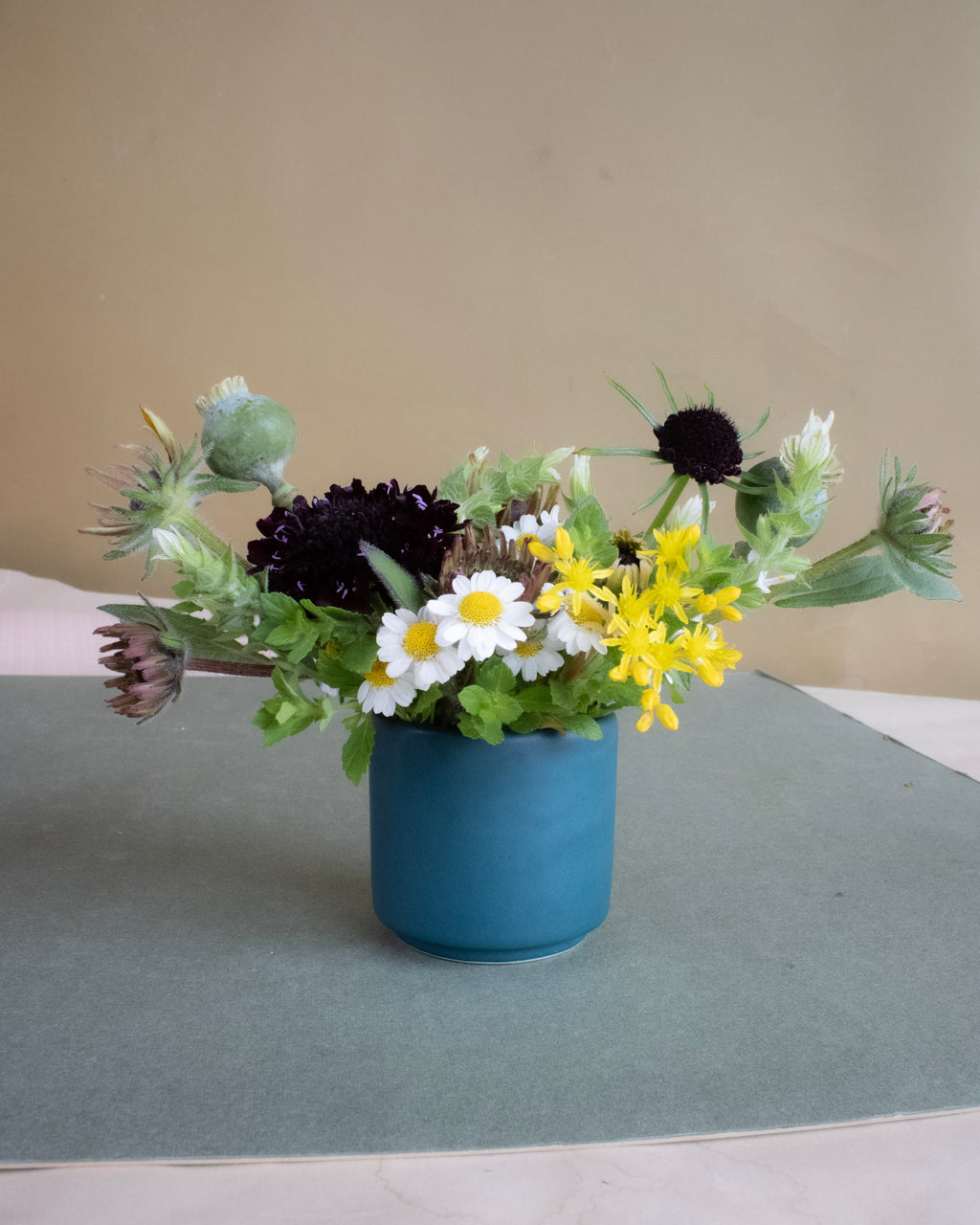 Blue vase with a bouquet of flowers on a gray surface