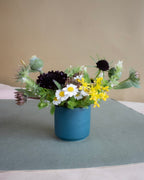 Blue vase with a bouquet of flowers on a gray surface