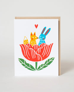 Illustration of a fox and a rabbit sitting inside a red flower with green leaves on a white background.